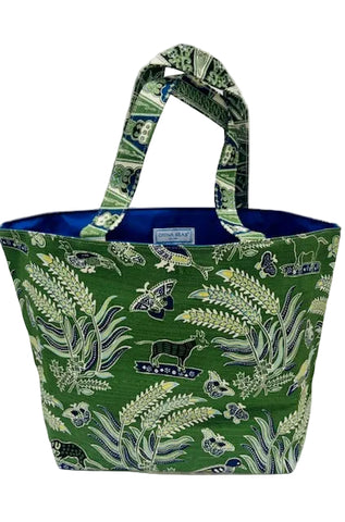 A green fabric tote bag with a botanical and butterfly pattern, featuring a blue interior lining and matching patterned handles, shown against a plain light background.