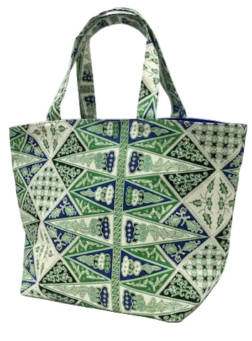 A fabric tote bag featuring a green, blue, and white geometric batik pattern, shown against a plain white background.