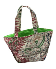 A fabric tote bag with a red, green, and cream botanical pattern
